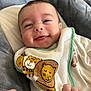 animal_print, apparel, baby, baby_toy, bib, blanket, child, closeup, comfort, cute, face, happy, head, indoors, infant, portrait, skin, smile, soft, young
