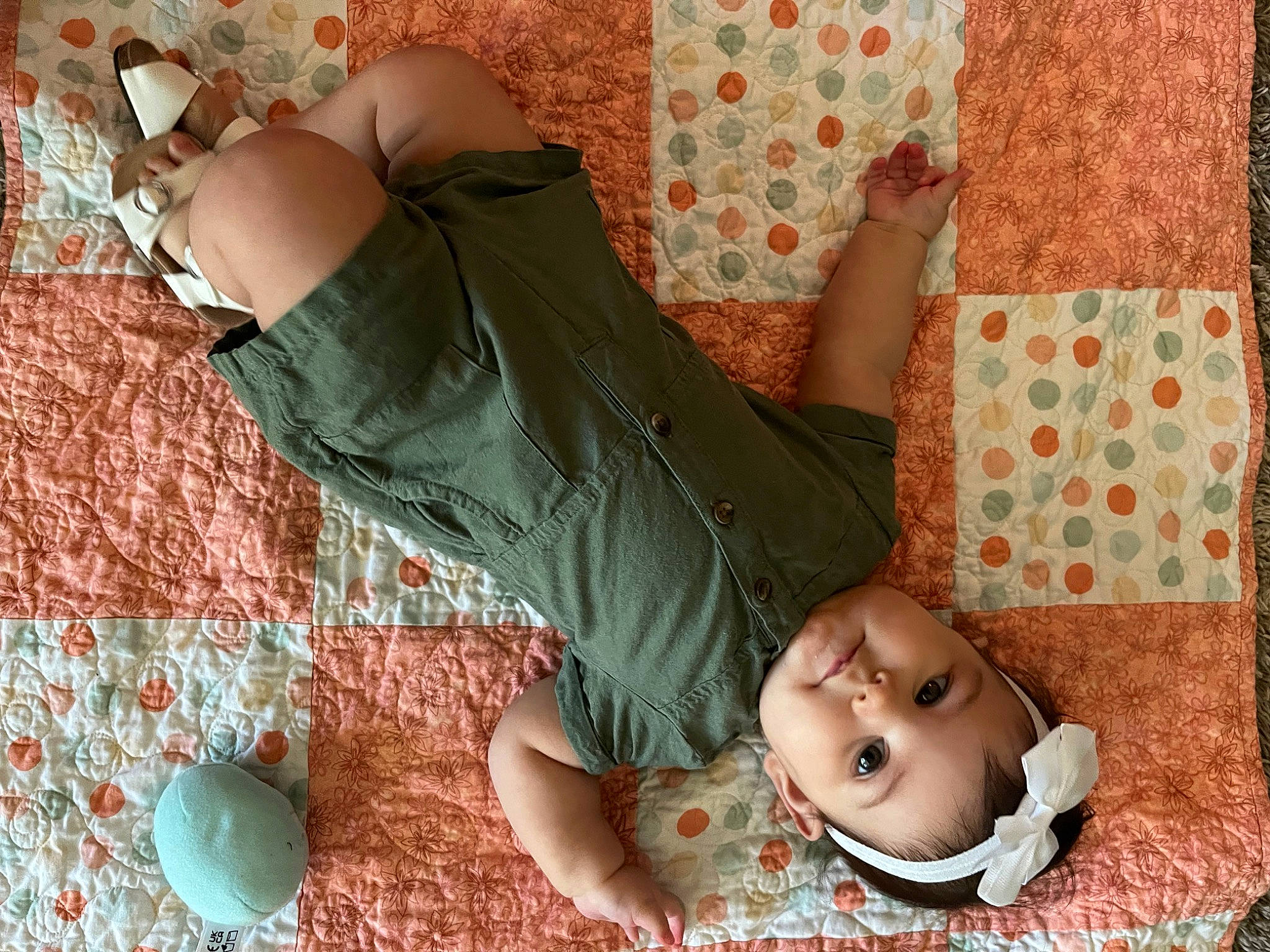 Kinsley joined the competition — help win amazing prizes! baby, baby_toddler_clothing, beauty, child, comfort, flooring, foot, grass, headwear, human_leg, knee, leisure, linens, pattern, peach, person, pink, room, sitting, thigh