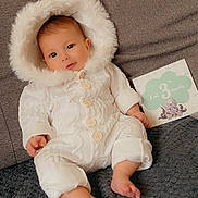 Amaya participe au concours pour gagner de l'argent avec cette photo : baby, infant, white_onesie, hood, couch, blanket, milestone_card, 3_months, cute, cozy, indoors, smiling, portrait, child, person, soft_texture, warm_clothing, happy, sitting, face