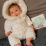 baby, infant, white_onesie, hood, couch, blanket, milestone_card, 3_months, cute, cozy, indoors, smiling, portrait, child, person, soft_texture, warm_clothing, happy, sitting, face