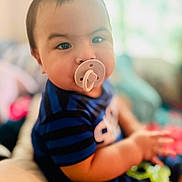 Noah joined the competition — help win amazing prizes! baby, pacifier, child, blue_clothing, striped_shirt, indoor, soft_light, portrait, sitting, cute, face, hand, young_child, closeup, infant, blurred_background, chubby_cheeks, person, focus, casual