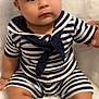 Noah is registered to the contest to win money with this photo: baby, child, infant, striped_clothing, white_bonnet, sitting, fluffy_surface, cute, chubby_cheeks, holding_hand, indoors, portrait, young_child, navy_blue, white, shorts, top, large_eyes, curious_expression, soft_texture
