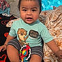 Noah joined the competition — help win amazing prizes! toddler, child, baby, toy, shirt, striped_shorts, bed, blanket, curtain, indoors, smiling, cute, chubby_cheeks, playful, person, clothing, colorful_toy, sitting, home, cozy