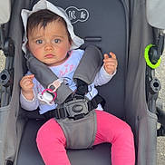 Maelie participe au concours pour gagner de l'argent avec cette photo : baby, stroller, child, hat, pink_pants, footwear, toy, pacifier, can, seatbelt, outdoor, expression, face, hands, feet, clothing, plaything, infant, safety_harness, sun_hat