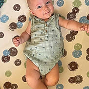 Naël participe au concours pour gagner de l'argent avec cette photo : baby, infant, child, onesie, smile, face, legs, arms, skin, pattern, dots, green, blue, brown, white, cute, expression, lying_down, indoor, soft_light