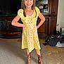 Rose Tuccino joined the competition — help win amazing prizes! child, girl, yellow_dress, cowboy_boots, smile, indoor, carpet, wooden_furniture, family_photos, happy, posing, long_hair, home, living_room, floor, cabinet, portrait, person, clothing, footwear