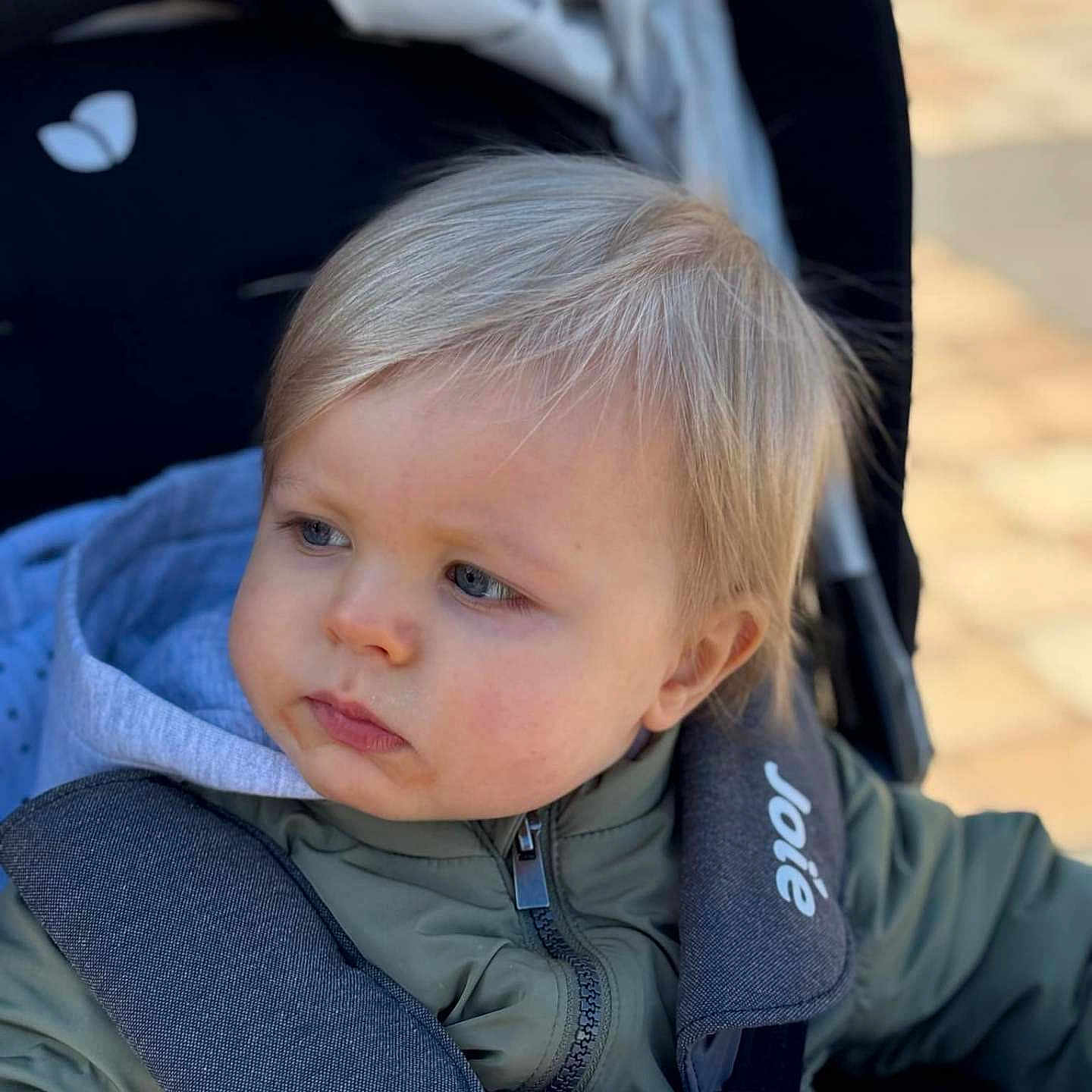 Ezyo participe au concours pour gagner de l'argent avec cette photo : baby, blonde, brownhair, clothing, coat, face, gun, hair, happy, head, jacket, pants, person, photography, portrait, sad, sitting, smile, stroller, weapon