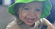 Rowan joined the competition — help win amazing prizes! child, toddler, smile, green_hat, cute, happy, face, teeth, clothing, overalls, person, indoors, portrait, baby, expression, headwear, casual, young_child, playful, fun