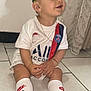 Youri participe au concours pour gagner de l'argent avec cette photo : toddler, child, sitting, soccer_jersey, paris_saint_germain, nike, white_socks, black_sneakers, floor, tile_floor, curtain, gold_chain, bracelet, indoor, smiling, cute, short_hair, ear, face, person