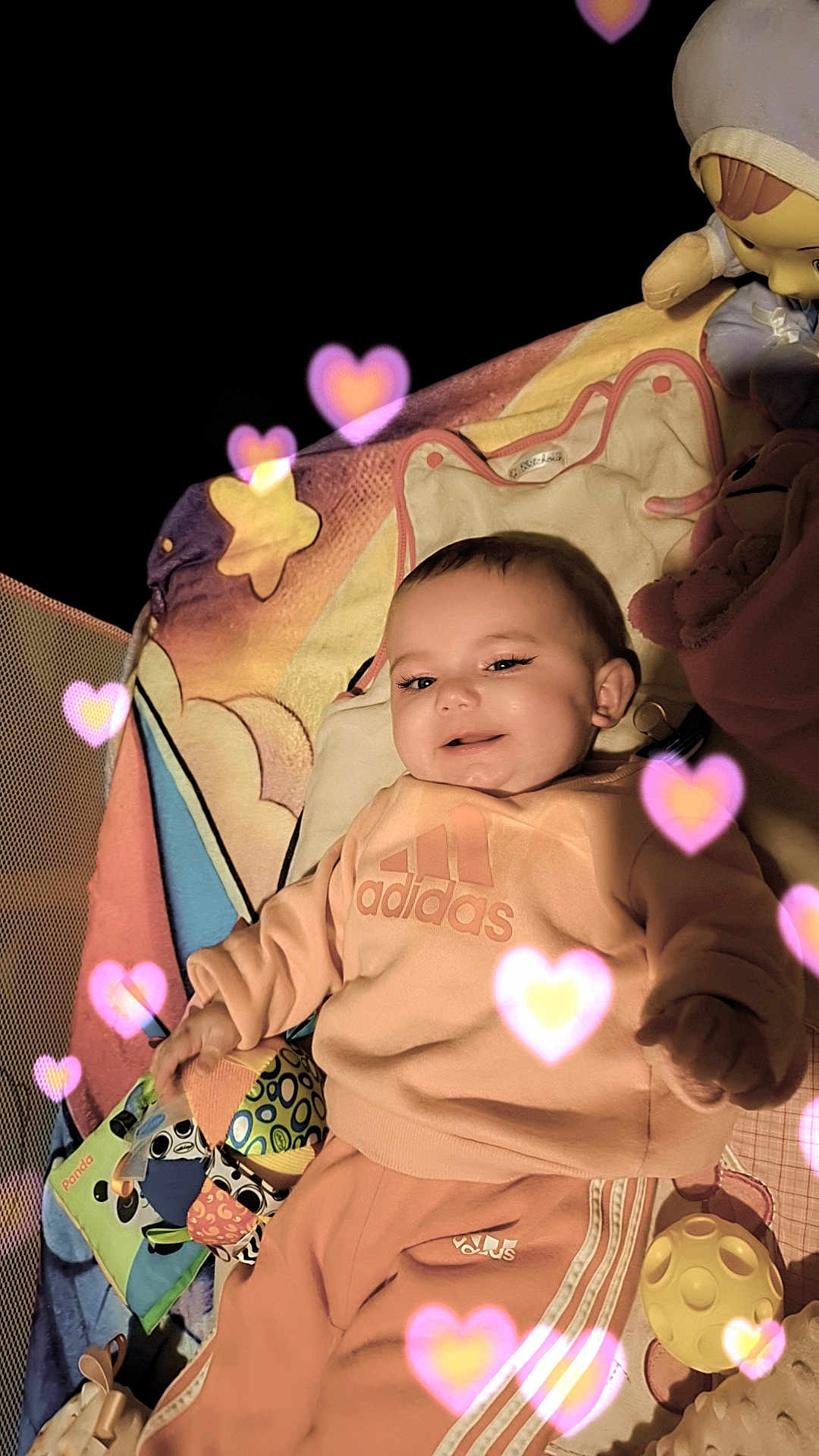Talya participe au concours pour gagner de l'argent avec cette photo : adidas, baby, blanket, casual, child, clothing, comfort, cute, happy, heart_effects, indoor, infant, orange, person, pink, playpen, portrait, smile, soft_lighting, toy