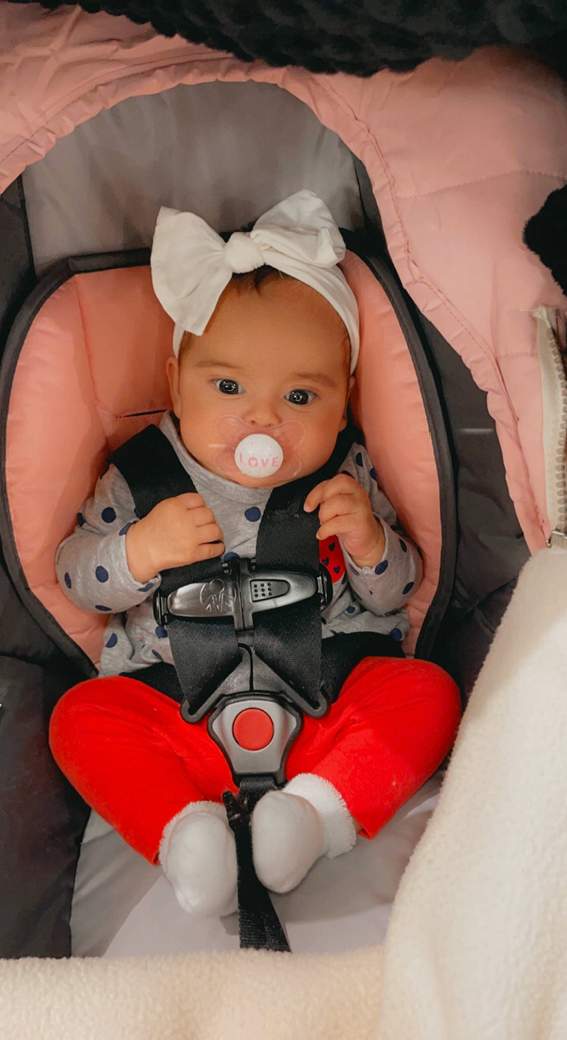 Kamilah is registered to the contest to win money with this photo: baby, baby_carriage, baby_products, car_seat, carmine, chair, cheek, child, comfort, eye, finger, headwear, human_body, lap, orange, person, sitting, stuffed_toy, textile, thumb