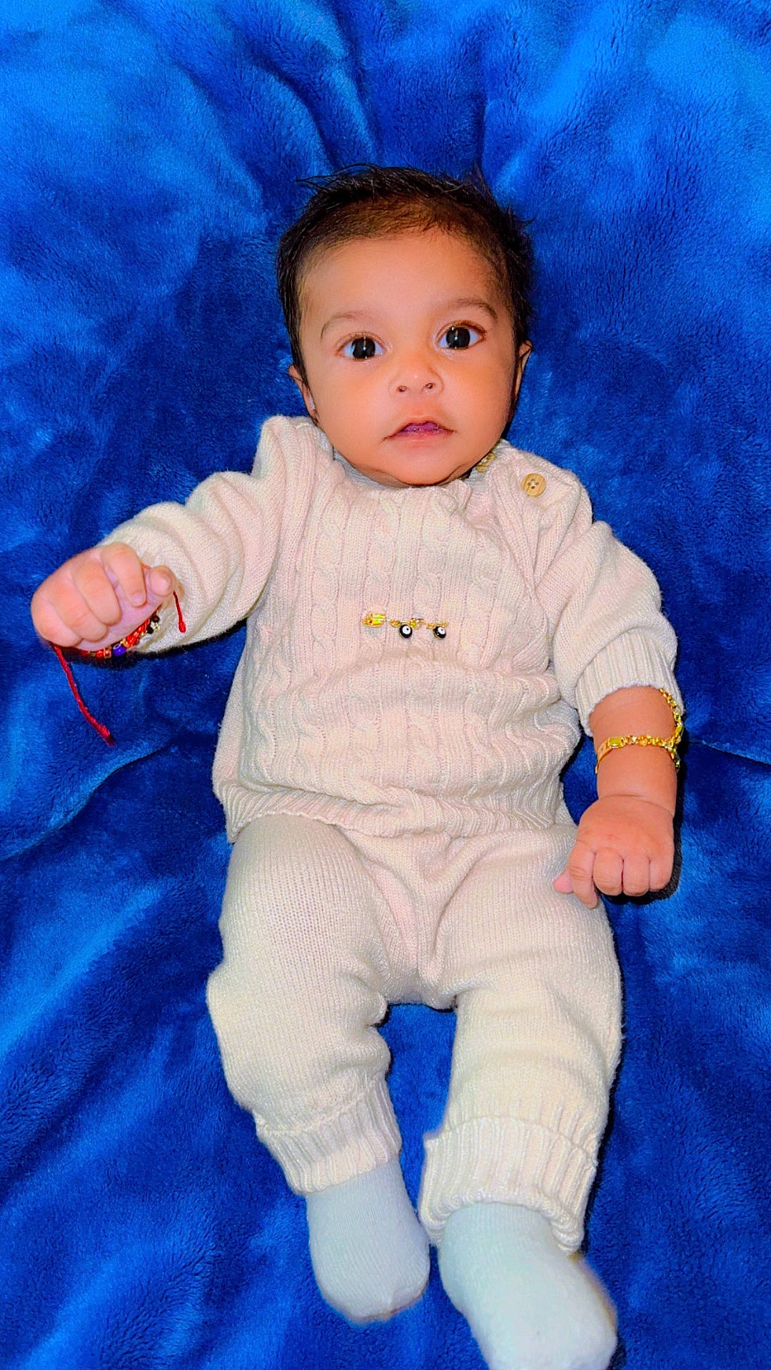 Ayaan is registered to the contest to win money with this photo: accessories, baby, bodypart, clothing, face, finger, hand, head, jewelry, knitwear, longsleeve, newborn, pants, person, photography, portrait, sitting, sleeve, sweater, toy