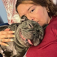 Mil is registered to the contest to win money with this photo: person, woman, dog, french_bulldog, pet, cuddling, sleeping, tongue_out, teeth, nails, ring, pillow, blanket, indoor, closeup, affection, jewelry, red_shirt, sofa, portrait