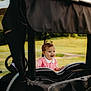 child, toddler, smiling, outdoor, grass, golf_cart, happy, baby, pigtails, nature, daylight, vehicle, greenery, cute, portrait, playing, pink_shirt, small_person, sunlight, joyful