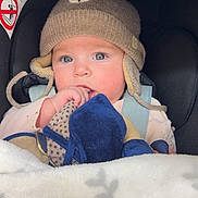 Romy participe au concours pour gagner de l'argent avec cette photo : baby, child, hat, knitted_hat, pom_pom, blanket, car_seat, blue_eyes, toy, cute, infant, warm_clothing, indoor, closeup, face, person, winter_wear, soft_toys, sitting, bundle