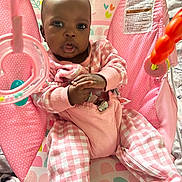 Kenzlee is registered to the contest to win money with this photo: baby, child, infant, sitting, bouncer, pink, plaid, polka_dots, toy, baby_toy, portrait, indoors, face, eyes, hands, clothing, pastel, patterned_background, infant_seat, photography