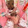 baby, child, infant, sitting, bouncer, pink, plaid, polka_dots, toy, baby_toy, portrait, indoors, face, eyes, hands, clothing, pastel, patterned_background, infant_seat, photography