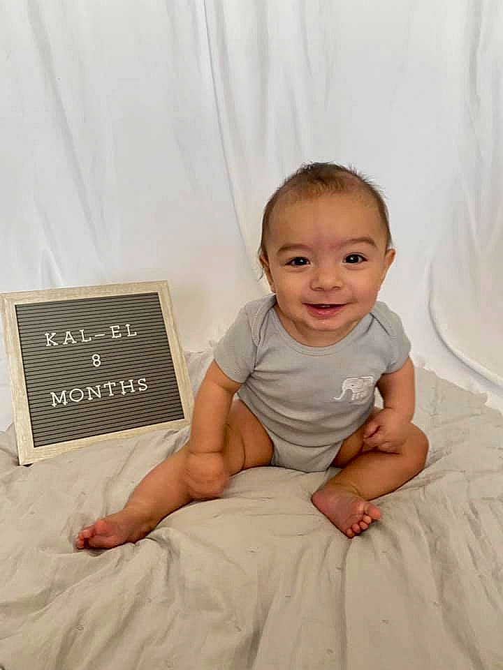 Kal-el joined the competition — help win amazing prizes! baby, baby_toddler_clothing, barefoot, child, comfort, dress, flash_photography, flooring, hand, handwriting, happy, head, human_leg, joy, pattern, person, rectangle, sitting, sleeve, smile