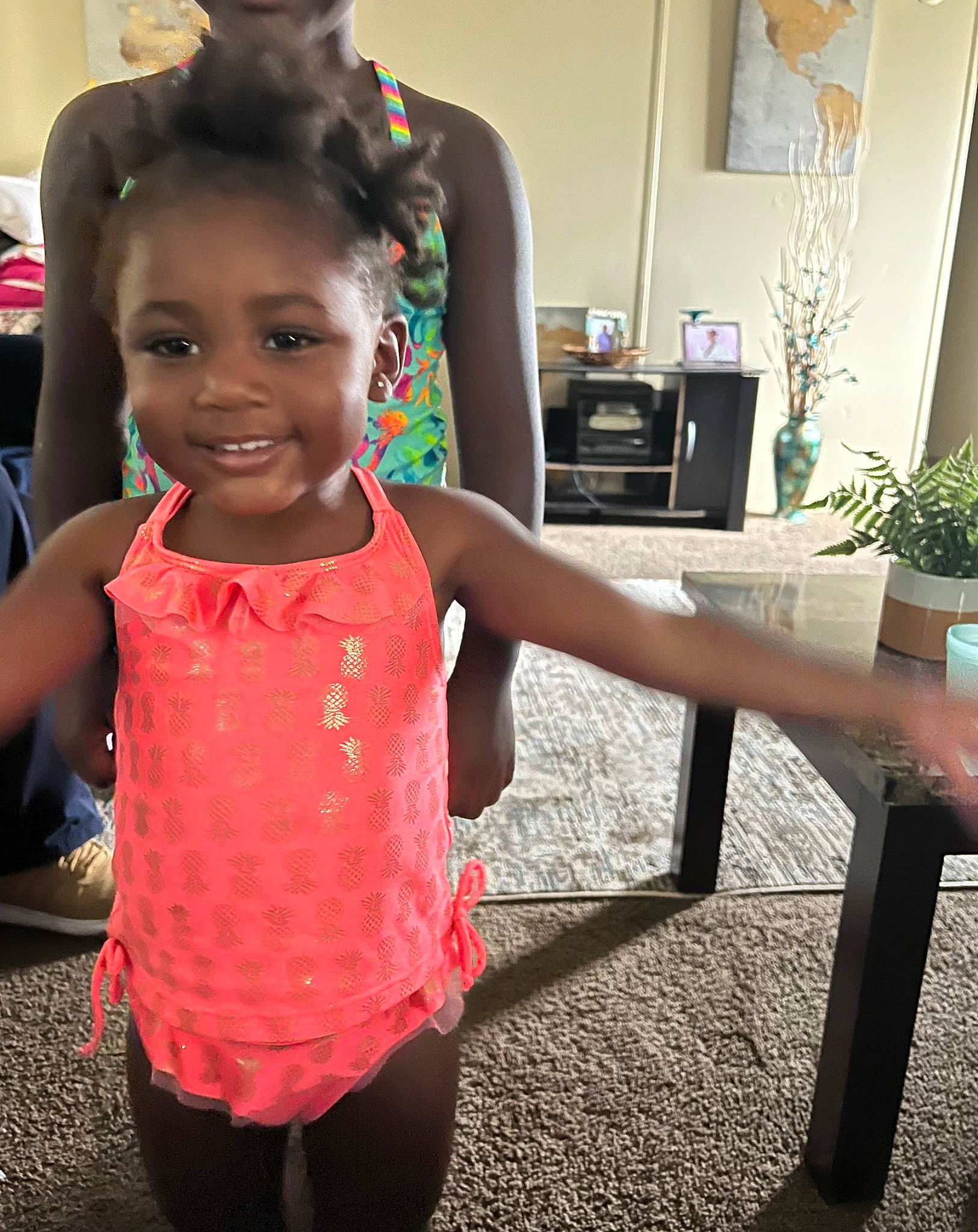 Genesis is registered to the contest to win money with this photo: child, event, fashion_design, flowerpot, fun, gesture, happy, houseplant, human_leg, joint, joy, leisure, person, plant, shoulder, smile, standing, t_shirt, thigh, toddler