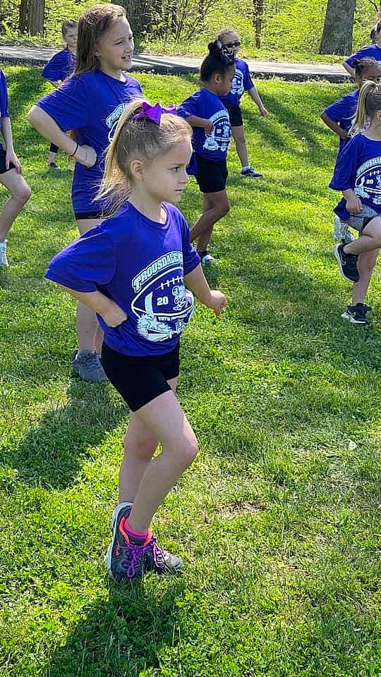 Makenna is registered to the contest to win money with this photo: active_shorts, athlete, athletics, blue, clothing, competition_event, electric_blue, exercise, fun, grass, joy, outdoor_recreation, person, player, recreation, running, shoe, shorts, sneakers, sports