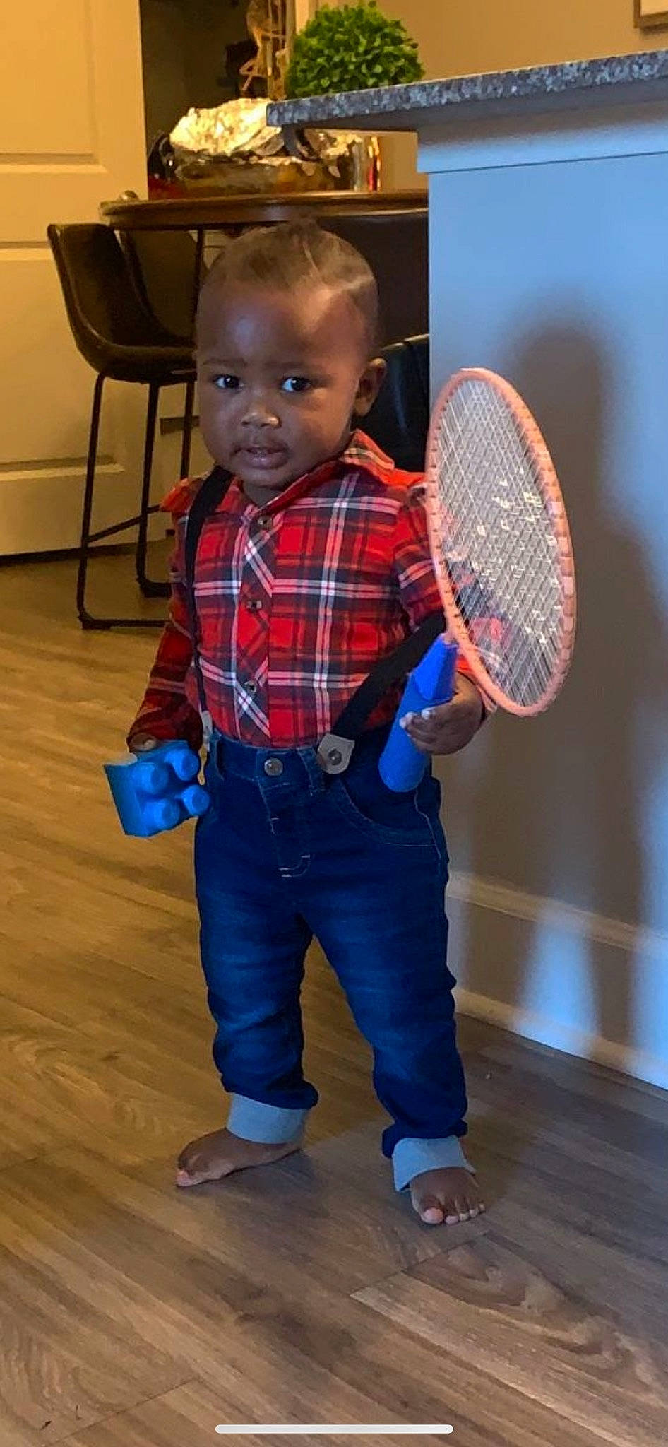 Bryson is registered to the contest to win money with this photo: electric_blue, flooring, fun, person, plaid, racket, racketlon, racquet_sport, skin, sleeve, sports_equipment, standing, strings, tartan, tennis, tennis_equipment, tennis_racket, tennis_racket_accessory, toddler, white