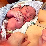 Syreese is registered to the contest to win money with this photo: newborn, baby, infant, hospital, blanket, hat, swaddle, umbilical_clamp, parent, hand, skin, closeup, postpartum, bed, towel, medical_equipment, sleeping, portrait, cute, newborn_room