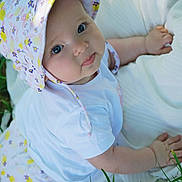 Hisaé a rejoint le concours — aidez-le/la à gagner de superbes lots ! baby, infant, child, hat, floral, white_clothing, blanket, grass, outdoor, cute, smile, face, eyes, skin, hand, nature, lying, person, young, sunlight