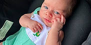Evo is registered to the contest to win money with this photo: baby, bib, blue_eyes, car_seat, child, clothing, cushion, cute, expression, face, green_outfit, hand, indoor, infant, newborn, portrait, resting, seat_belt, skin, soft_fabric