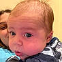 Evo is registered to the contest to win money with this photo: baby, child, face, person, portrait, curious, wide_eyes, hair, patterned_clothing, indoor, smiling_adult, background, close_up, skin, head, expression, young, infant, human, candid
