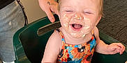 Azelia Lynn joined the competition — help win amazing prizes! baby, child, high_chair, smiling, happy, face_paint, frosting, food, messy, tattoo, arm, table, chair, indoor, carpet, person, colorful_clothing, dining_room, laughter, cute