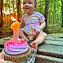 Azelia Lynn is registered to the contest to win money with this photo: toddler, birthday, cupcake, candle, outdoor, forest, trees, headband, striped_clothing, smiling, baby, celebration, child, happy, wooden_surface, nature, first_birthday, party, sitting, diaper