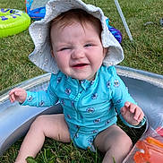 Azelia Lynn joined the competition — help win amazing prizes! baby, child, infant, sunhat, swimsuit, inflatable_pool, grass, outdoor, summer, cute, sitting, blue, floral_pattern, playtime, fun, sunny, expression, skin, legs, hand