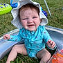 baby, child, infant, sunhat, swimsuit, inflatable_pool, grass, outdoor, summer, cute, sitting, blue, floral_pattern, playtime, fun, sunny, expression, skin, legs, hand