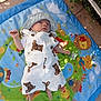 baby, infant, hat, overalls, bear_print, play_mat, outdoor, sunlight, shade, cartoon_animals, grass, leaves, colorful, child, cute, baby_clothes, relaxing, small, person, nature