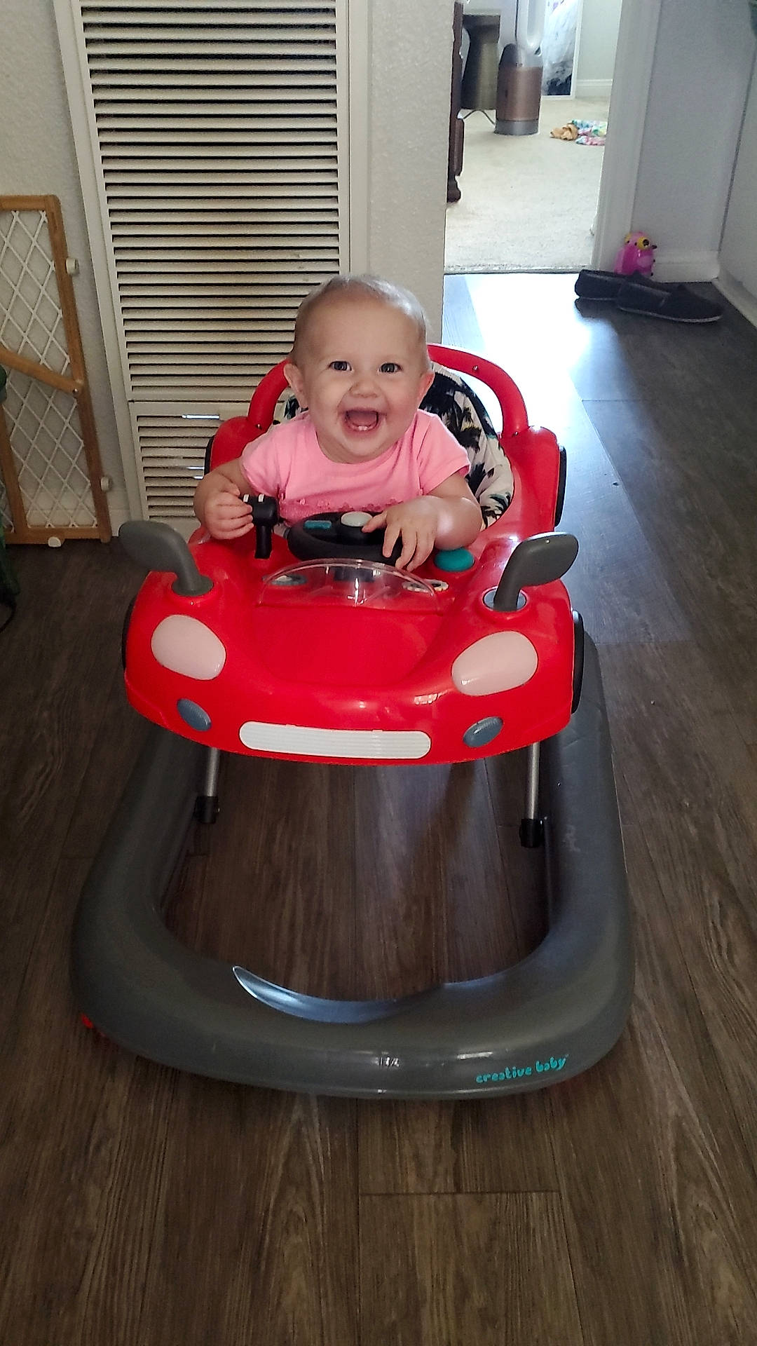 Ella joined the competition — help win amazing prizes! baby, baby_products, baby_toddler_clothing, baby_toys, door, face, floor, flooring, fun, joy, person, recreation, riding_toy, sitting, smile, tire, toddler, toy, toy_vehicle, vehicle