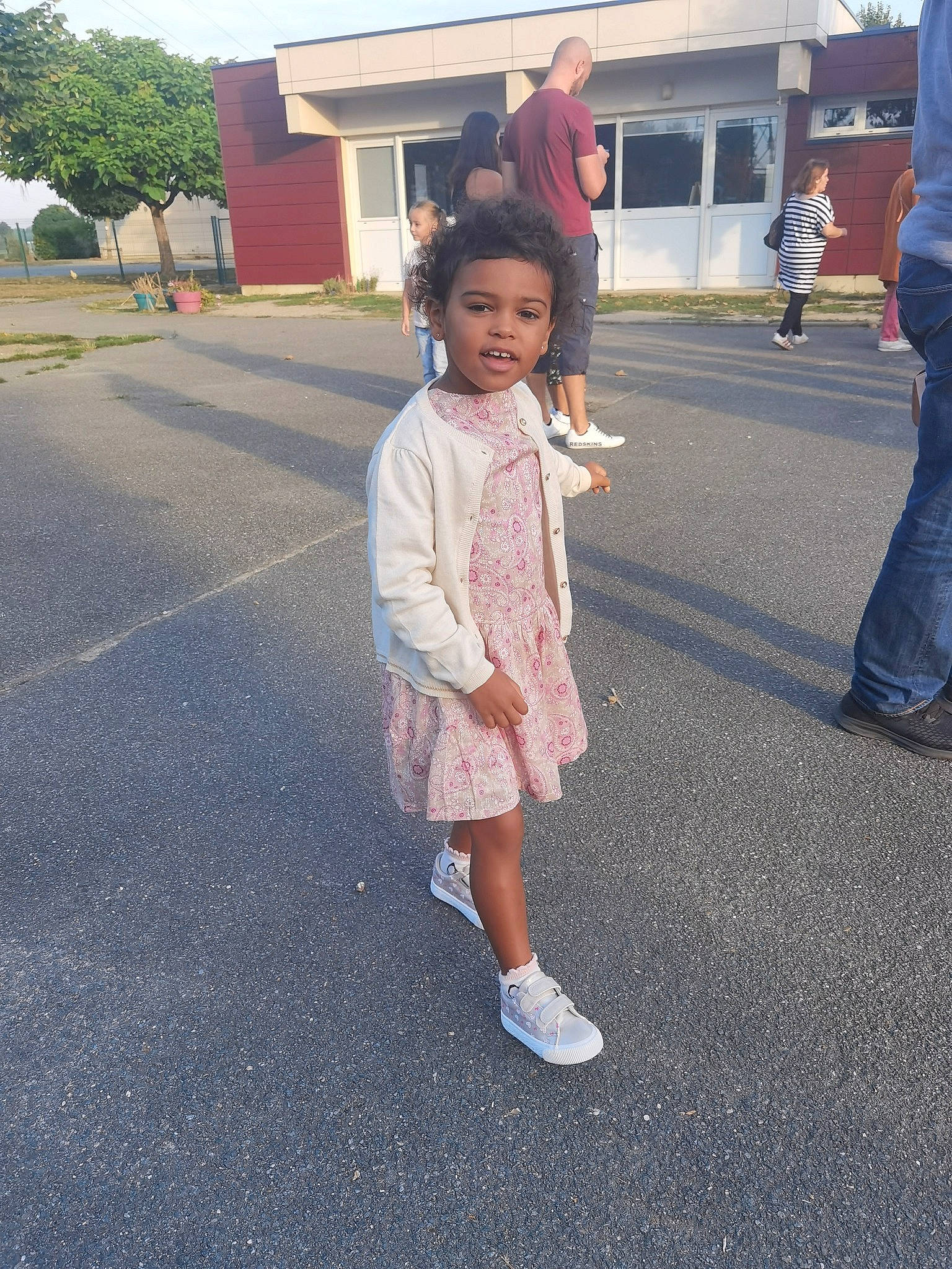 Talia participe au concours pour gagner de l'argent avec cette photo : asphalt, building, footwear, fun, gesture, lane, leisure, pattern, pedestrian, person, plant, recreation, road, road_surface, sidewalk, street, toddler, travel, tree, walking