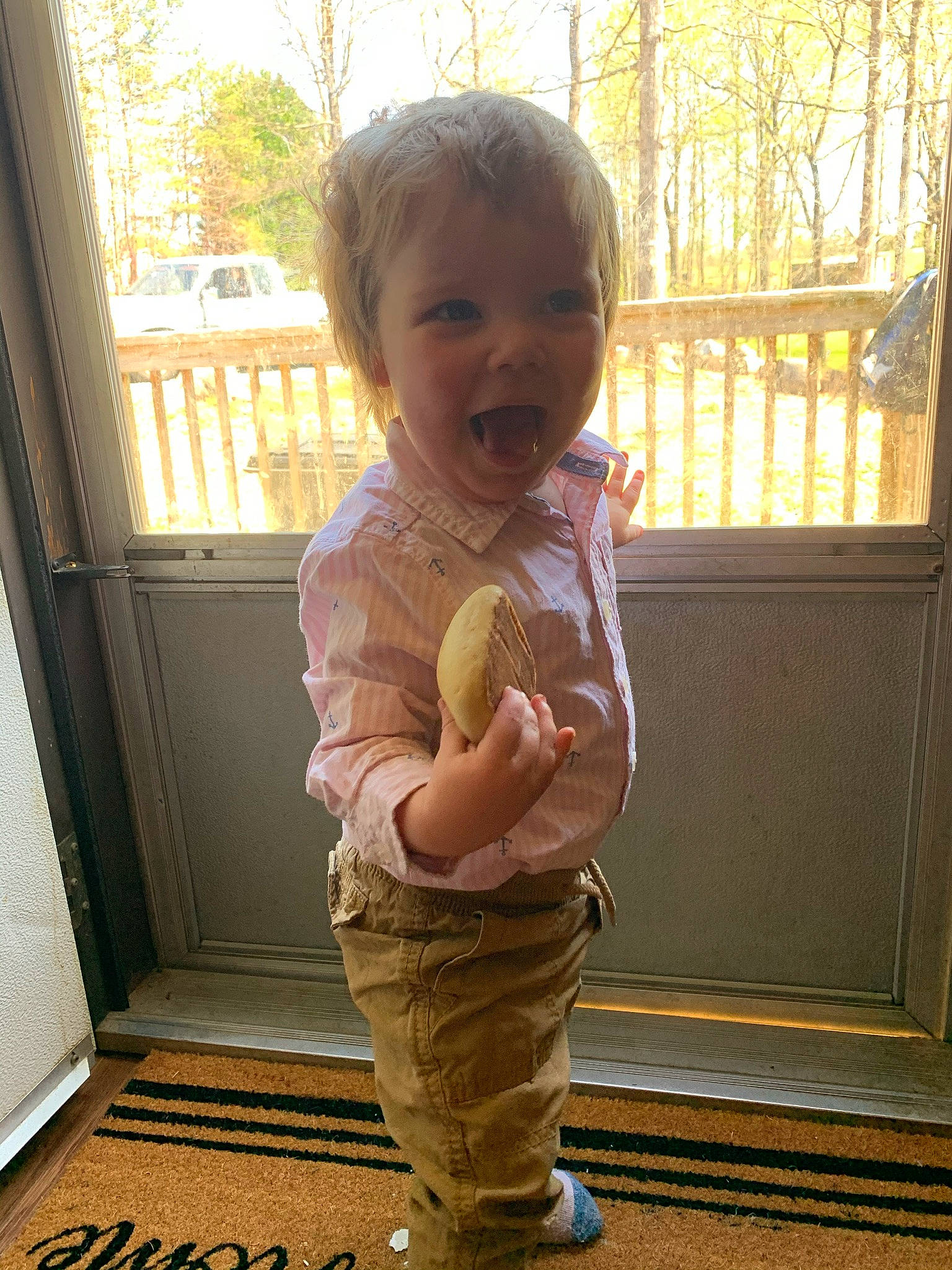 Gary is registered to the contest to win money with this photo: arm, baby, baby_toddler_clothing, cheek, gesture, hair, happy, joint, nose, person, skin, sleeve, smile, standing, thumb, toddler, tree, trunk, waist, window