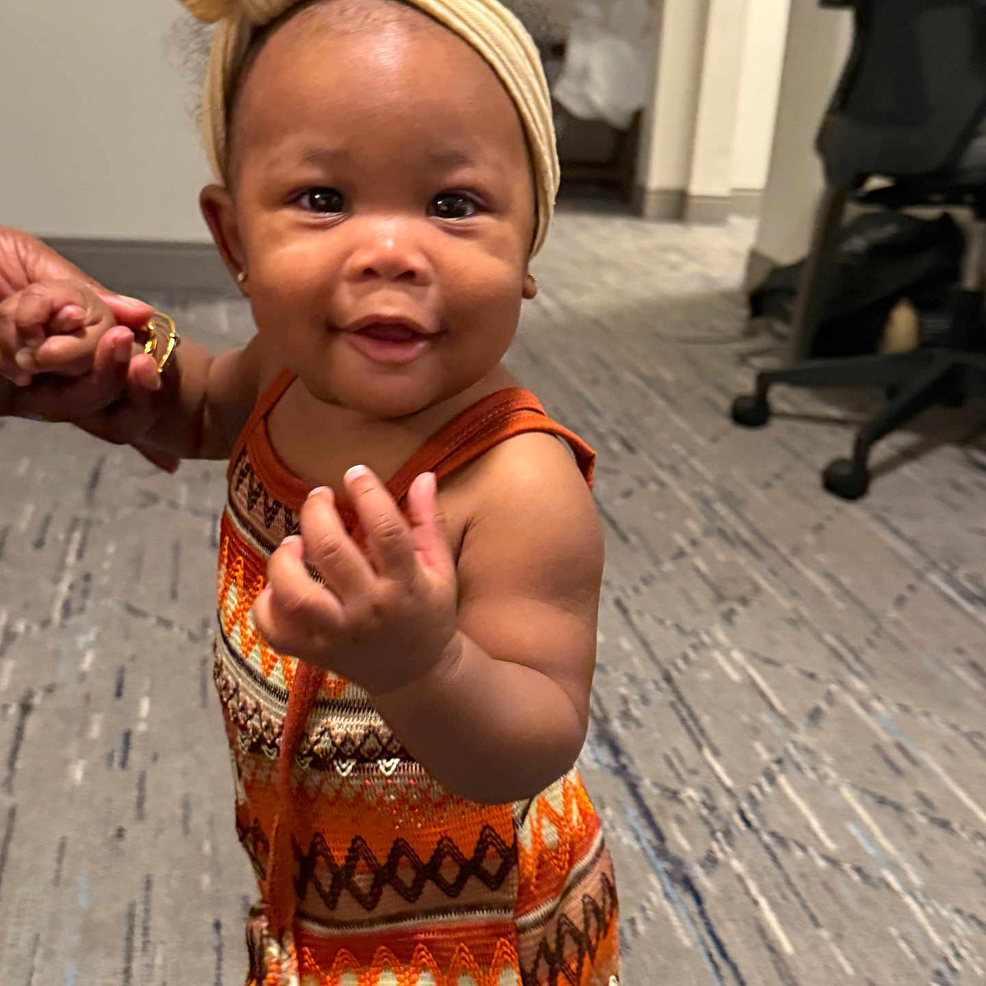 Aubrielle joined the competition — help win amazing prizes! baby, bow, carpet, child, colorful_clothing, cute, face, hand_holding, happy, headband, indoor, office_chair, person, portrait, skin, smiling, standing, support, toddler, young_child