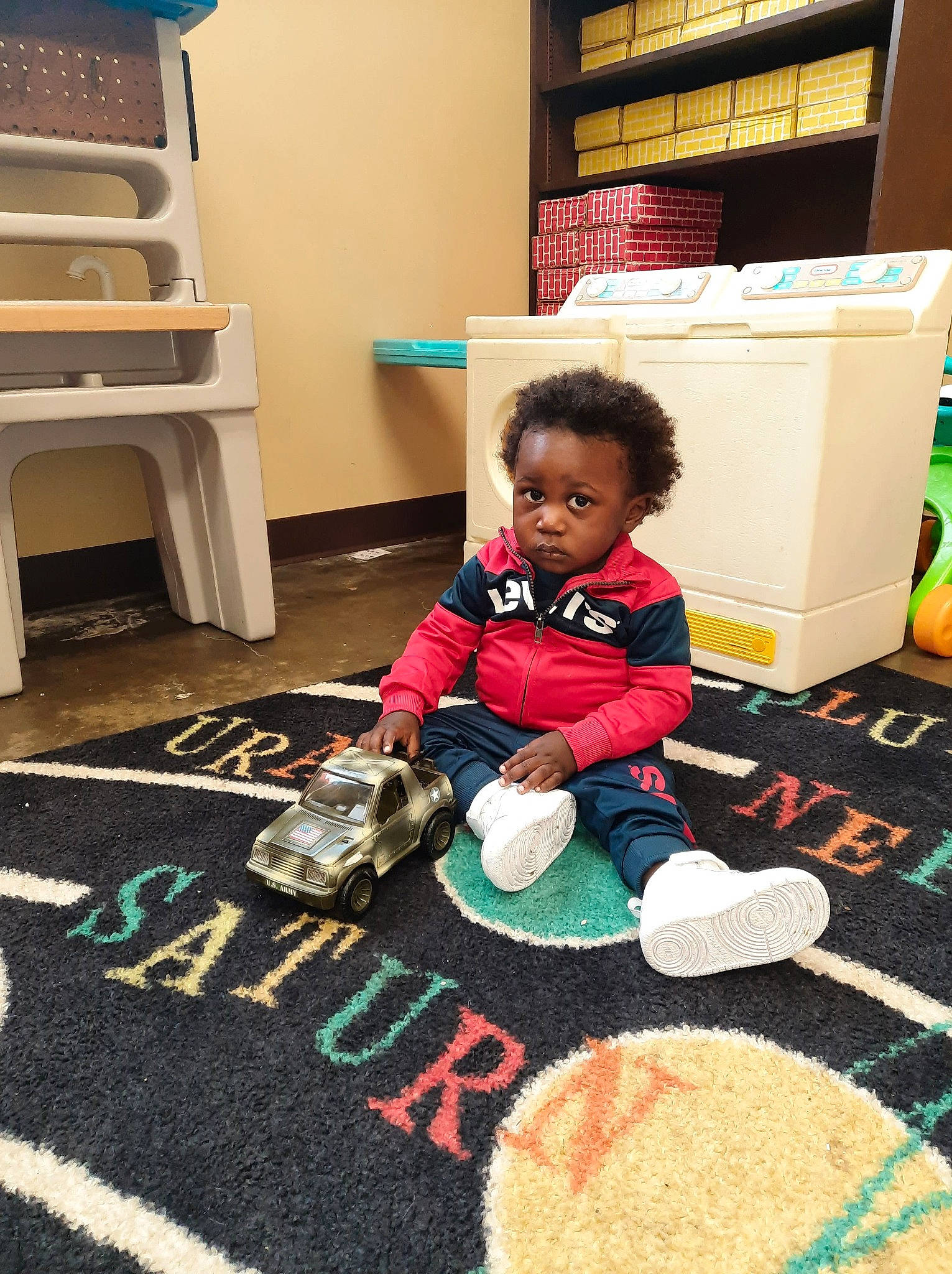 Kassius joined the competition — help win amazing prizes! art, baby, carpet, child, floor, flooring, fun, hardwood, linens, mat, pattern, person, play, playmat, room, rug, sitting, t_shirt, toddler, toy