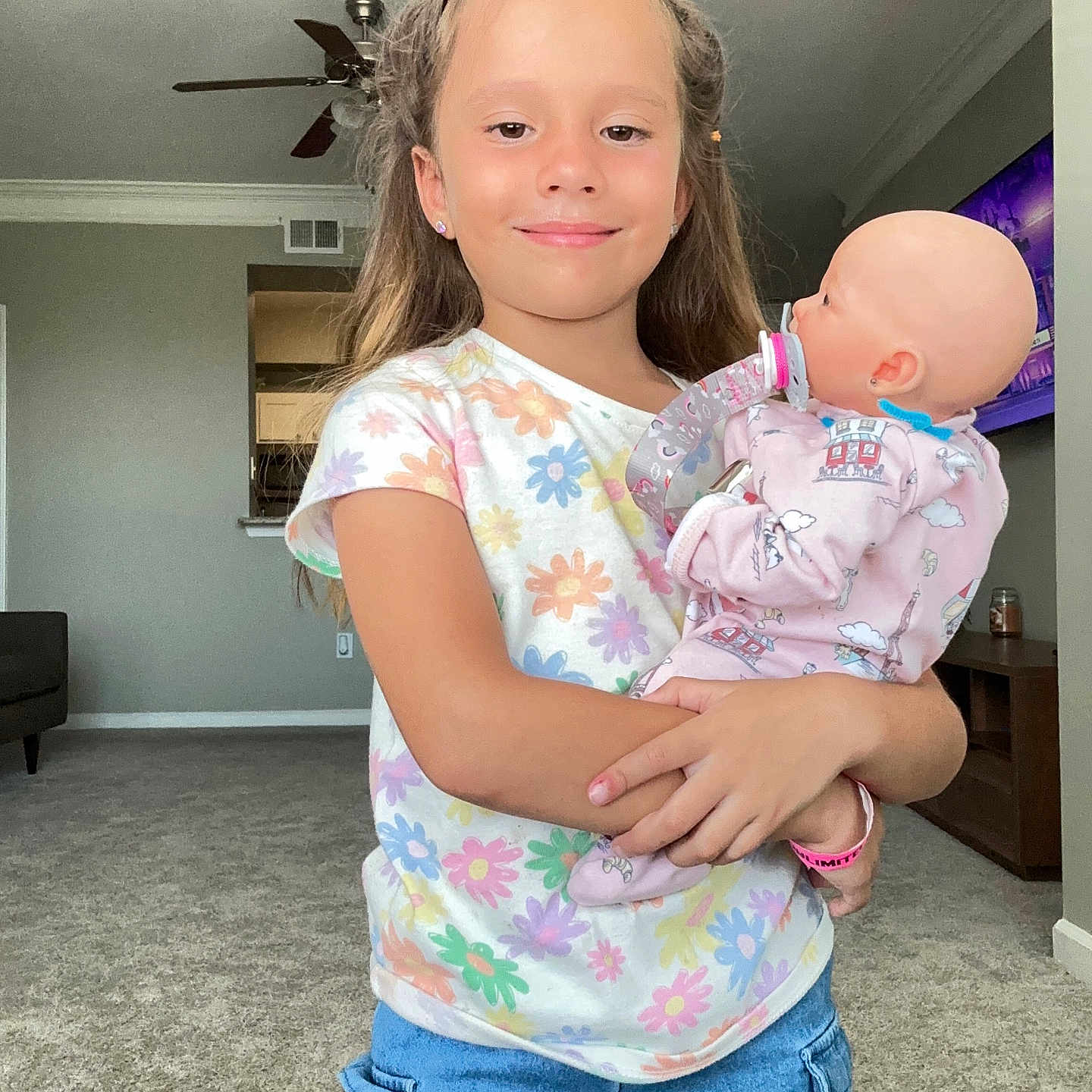 Matilda is registered to the contest to win money with this photo: appliance, baby, blouse, ceilingfan, clothing, device, doll, door, electricaldevice, face, head, homedecor, jeans, pants, person, photography, portrait, sleeve, t_shirt, toy