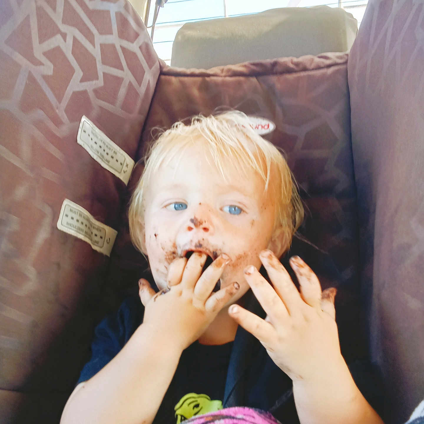 Ollie-Ray joined the competition — help win amazing prizes! blanket, blond_hair, blue_eyes, car_interior, car_seat, child, chocolate, cute, dirty_face, eating, fingers, hands, messy_face, patterned_seat, portrait, seat, sunlight, toddler, tshirt, window