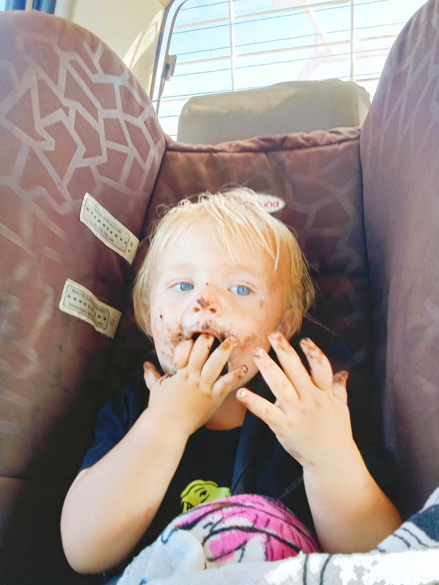 Ollie-Ray joined the competition — help win amazing prizes! blanket, blond_hair, blue_eyes, car_interior, car_seat, child, chocolate, cute, dirty_face, eating, fingers, hands, messy_face, patterned_seat, portrait, seat, sunlight, toddler, tshirt, window