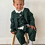 Mylann participe au concours pour gagner de l'argent avec cette photo : child, boy, smile, suit, bow_tie, green_clothing, white_shirt, sneakers, wooden_stool, indoor, portrait, happy, cute, fashion, young, person, casual, floor, wall, seated