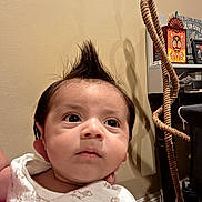 Thaddeus is registered to the contest to win money with this photo: baby, infant, child, portrait, face, wide_eyes, serious_expression, mohawk, hair, onesie, clothing, indoor, home, rope_swing, rope, shelf, owl_art, furniture, close_up, photography