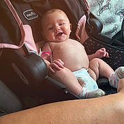 Eliana is registered to the contest to win money with this photo: baby, car_seat, diaper, smile, socks, child, infant, happy, cute, seat, blanket, cartoon, indoor, person, skin, hand, foot, comfort, relax, expression