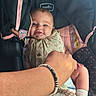 Eliana joined the competition — help win amazing prizes! baby, infant, car_seat, smiling, hand, bracelet, clothing, socks, blanket, person, child, cute, seated, comfort, indoor, closeup, tender, care, face, portrait