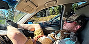 Boon joined the competition — help win amazing prizes! cap, car_interior, casual, cuddling, dashboard, dog, man, passing_car, pet, relaxed, resting, road, seat, shorts, sunglasses, sunlight, tattoo, trees, vehicle, window