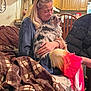 Lucas joined the competition — help win amazing prizes! woman, dog, indoor, couch, blanket, cuddling, kitchen, wooden_cabinet, glasses, long_hair, colorful_skirt, chair, home, comfort, pet, affection, casual_clothing, seated, furniture, domestic