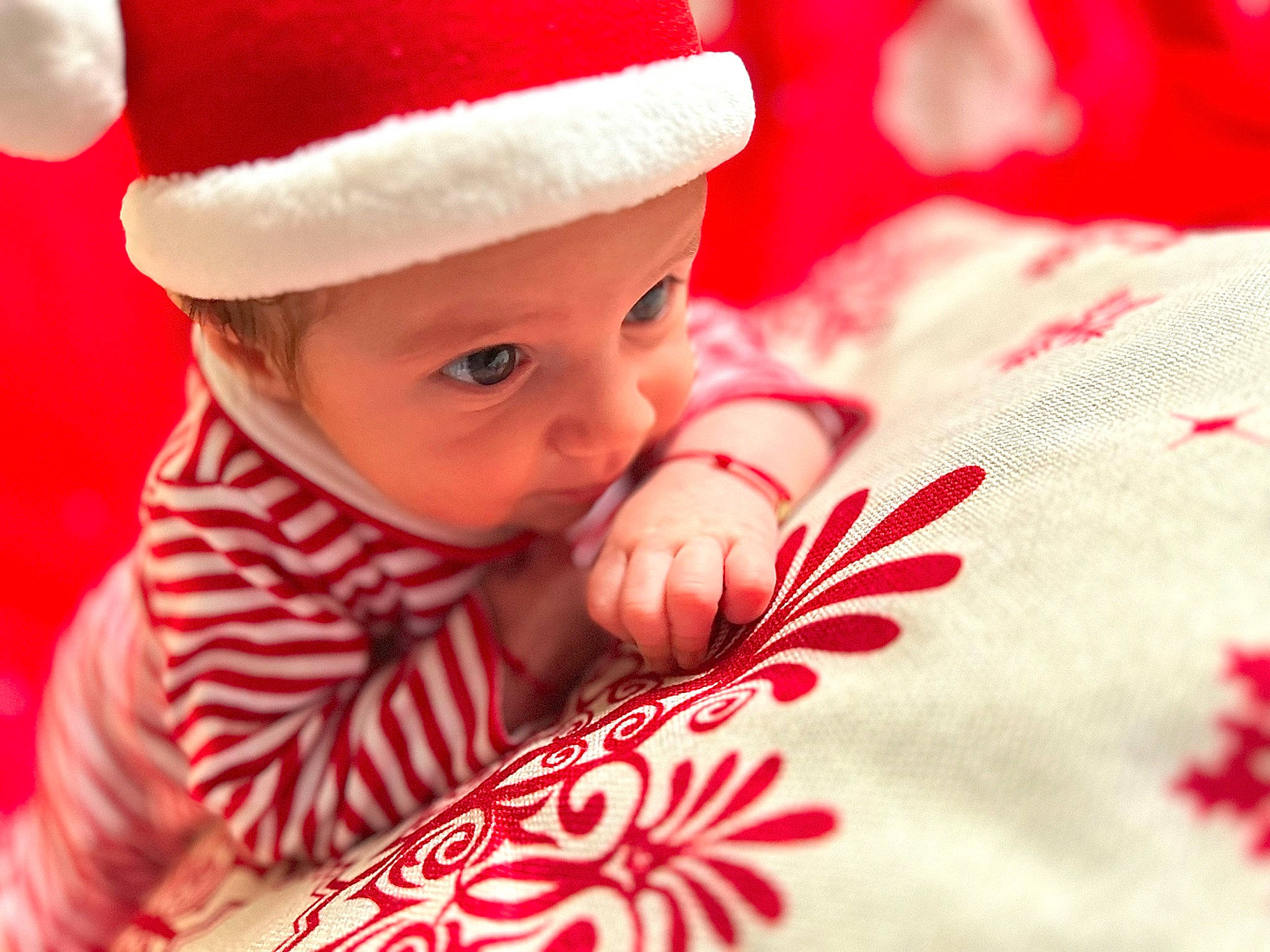 Darius is registered to the contest to win money with this photo: baby, baby_toddler_clothing, cap, child, christmas, comfort, event, face, facial_expression, happy, hat, head, headwear, holiday, mammal, person, red, skin, sleeve, smile