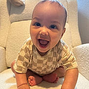 Tru joined the competition — help win amazing prizes! baby, child, smiling, crawling, indoor, chair, cozy, happy, cute, infant, person, face, hands, feet, clothing, checkered, pattern, light, portrait, home